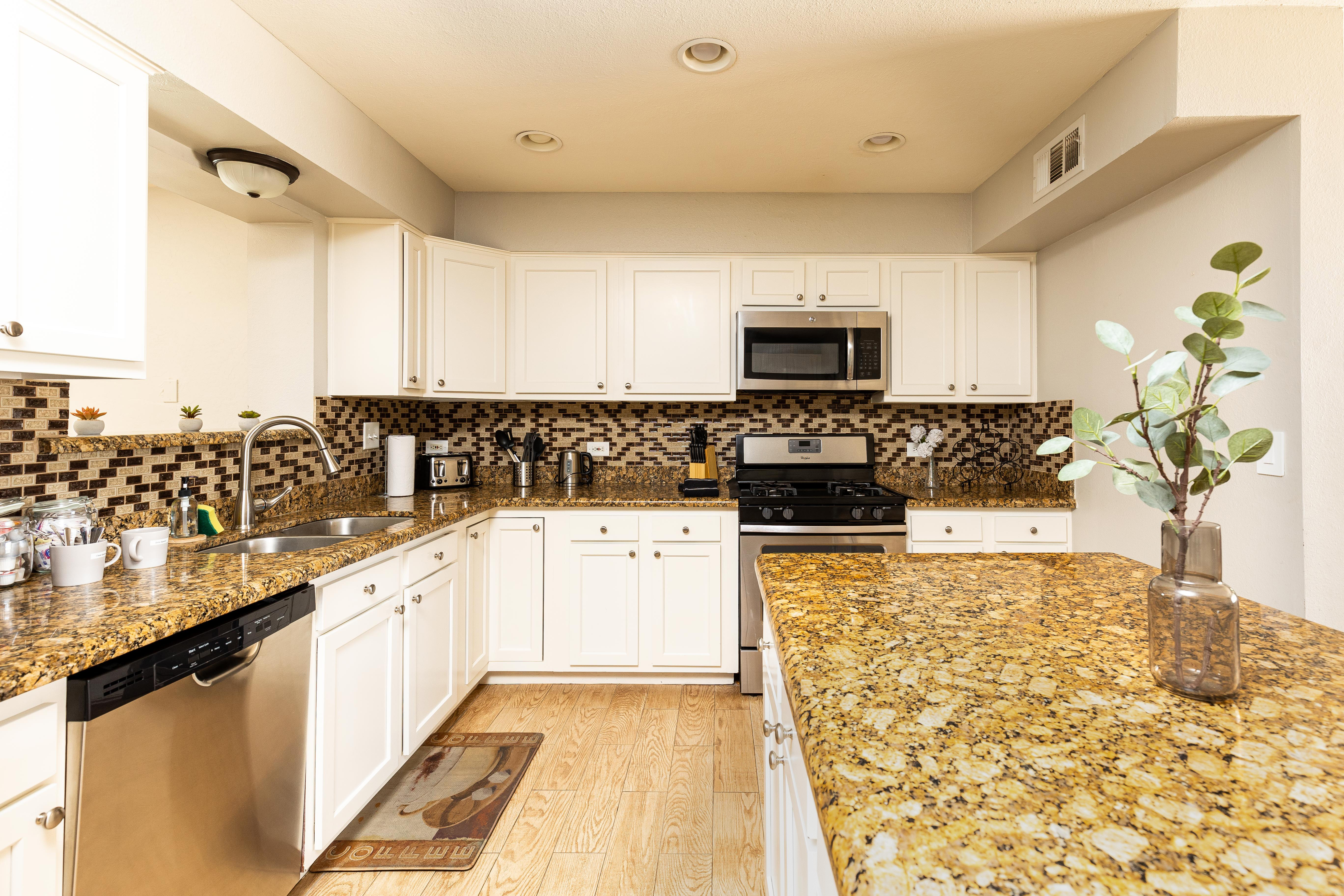 Monterey house kitchen with white cabinets and granite counters